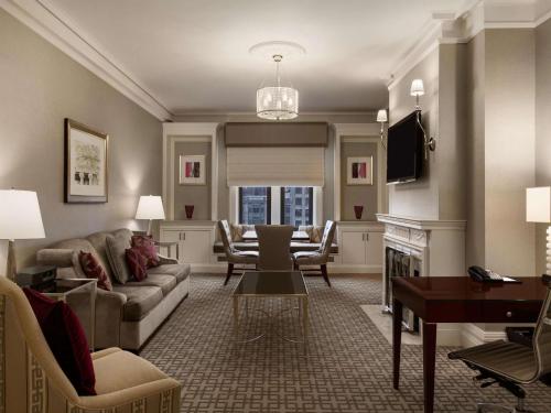 a living room with a couch and a table at Fairmont Copley Plaza in Boston