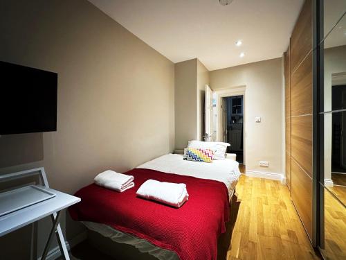a small bedroom with a bed with red blanket at David’s Place in EastEnd in London