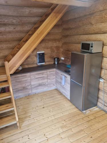 uma cozinha num chalé de madeira com um frigorífico em Lebola Puhkemaja em Kasaritsa
