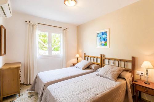 2 camas en un dormitorio con ventana en Villa CAN CAULES, en Son Bou