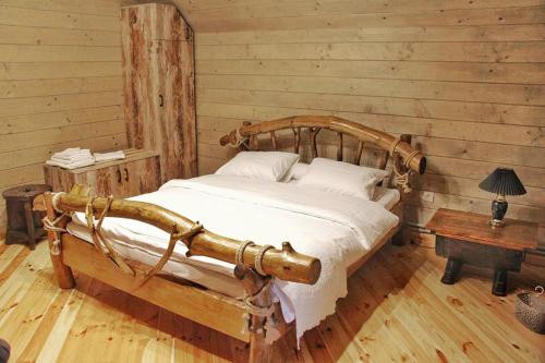 um quarto com uma cama num chalé de madeira em Villa Tukhlay em Tukhlya
