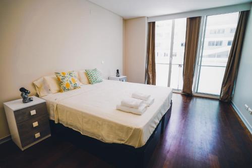 una camera da letto con un letto grande con asciugamani sopra di Funchal Centrum Apartment a Funchal