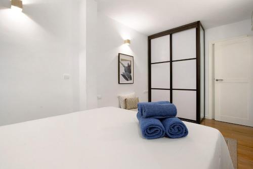 Un dormitorio con una cama blanca con toallas azules. en Bajondillo Playa, en Torremolinos
