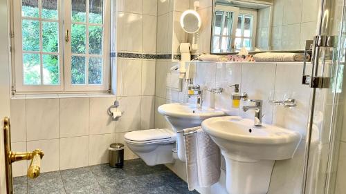 La salle de bains blanche est pourvue de toilettes et d'un lavabo. dans l'établissement Haus Strandgut FW 3, à Ahrenshoop