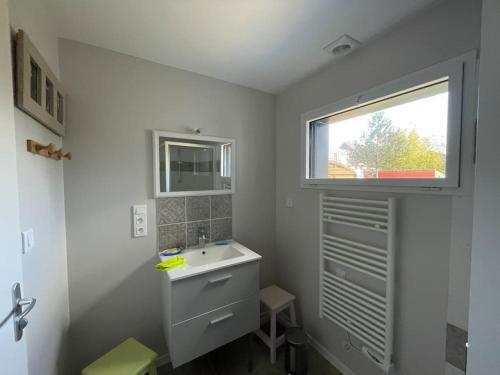 une salle de bain blanche avec un lavabo et une fenêtre dans l'établissement Studio au calme avec jardin et stationnement, à Vannes