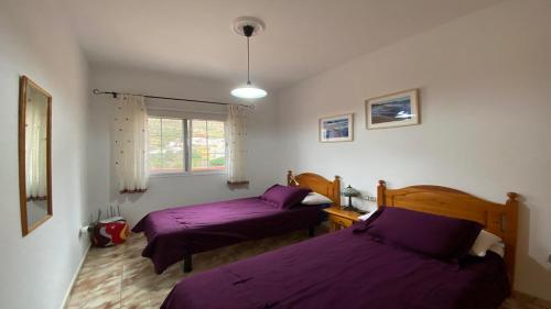 duas camas num quarto com lençóis roxos em Casa Oneida em Valle Gran Rey