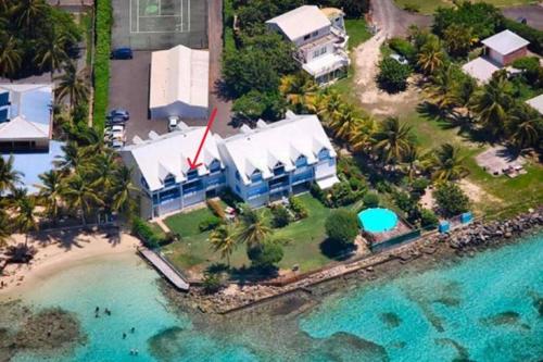 eine Luftansicht eines Hauses am Strand in der Unterkunft Ti MACLOA - Appartement les pieds dans l'eau in Sainte-Anne