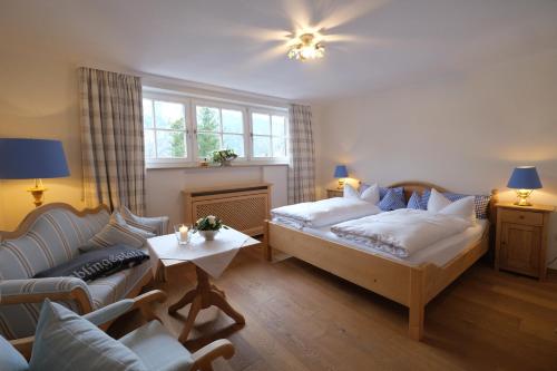 a living room with a bed and a couch at Hotel Maier zum Kirschner in Rottach-Egern