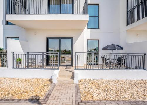a building with a patio with tables and an umbrella at ZAPBED House - Luxury Holiday Homes in Yas Island in Abu Dhabi