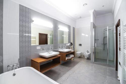a bathroom with two sinks and a large mirror at Hotel Michael's Palace in Košice
