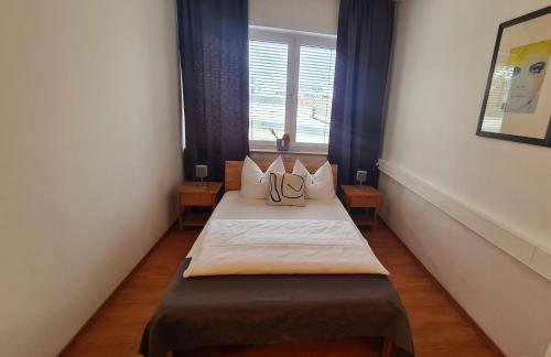 a small room with two beds with a window at Horn Gästehaus in Leinfelden-Echterdingen