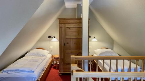 Zimmer im Dachgeschoss mit 2 Betten und einer Treppe in der Unterkunft Haus Strandgut FW 6 in Ahrenshoop