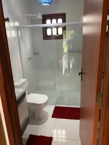 y baño con aseo y ducha acristalada. en Chalé Quartzo no Recanto Diamantina entre Palmeiras e Capão, en Palmeiras