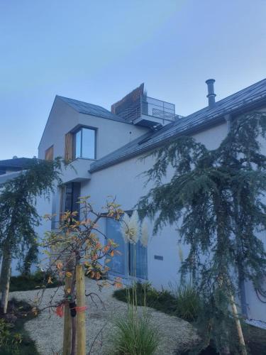 a white building with trees in front of it at Urban Mountain Splitlevel with Lake View in Maurach