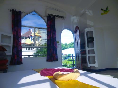 a room with a bed with a view of a balcony at Franswa Inn in El Nido