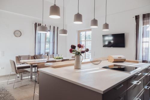 a kitchen and living room with a table with flowers on it at Grenzblick in Eisenberg an der Pinka