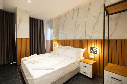 um quarto com uma grande cama branca num quarto em Aglon Twin's Hotel em Vlorë