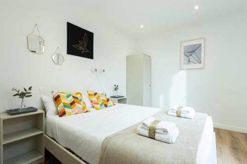 2 camas en un dormitorio con paredes blancas en INSIDEHOME Apartments - La Casita de Oscar, en Palencia