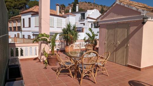 een patio met een tafel en stoelen op een balkon bij Casa Monte Victoria in Málaga