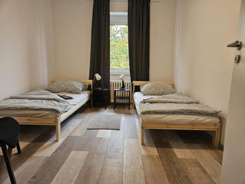 2 camas en una habitación con ventana en Ideale Unterkunft für Geschäftsreisende, Studenten, Monteure in Essen, en Essen