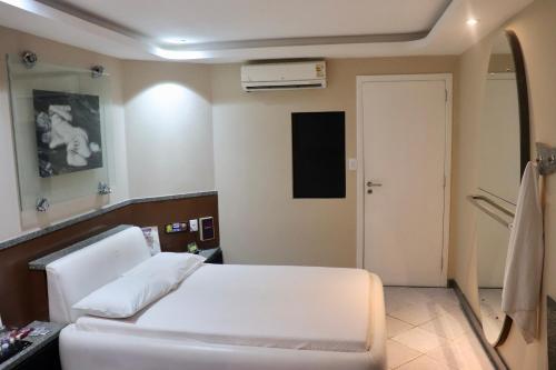 a hospital room with a white bed and a mirror at Motel Scala in Salvador