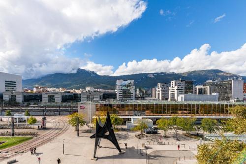 a city with a statue in the middle of a city at Hôtel Terminus in Grenoble