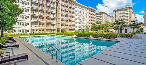 a swimming pool in front of a large building at Fairview Trees Residences Staycation in Manila