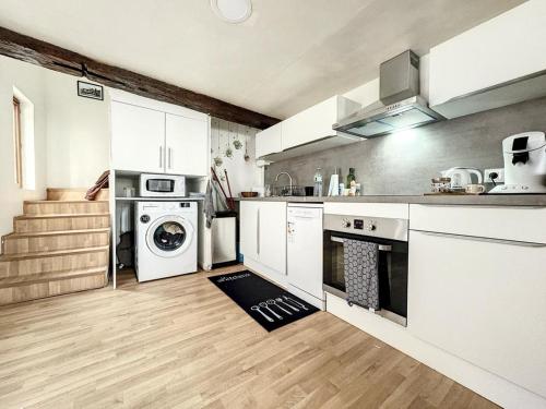 cocina con armarios blancos, lavadora y secadora en Duplex Cosy 85 m2 hyper centre Châlons-en-Champagne, en Châlons-en-Champagne