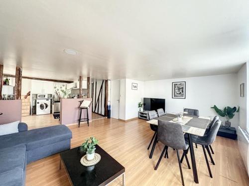 een woonkamer met een blauwe bank en een tafel bij Duplex Cosy 85 m2 hyper centre Châlons-en-Champagne in Châlons-en-Champagne