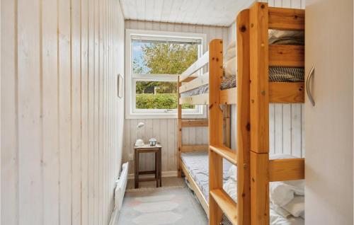 3 Bedroom Amazing Home In Nyborg في نيوبورغ: غرفة مع أسرة بطابقين في منزل صغير