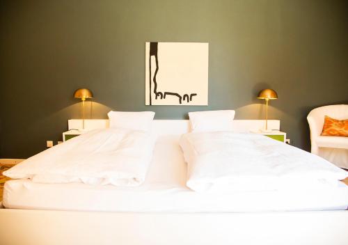 duże białe łóżko z 2 poduszkami w sypialni w obiekcie Villa Bulfon w mieście Velden am Wörthersee