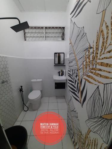 a bathroom with a toilet and a wall with a mural at MATIINJANNAH HOMESTAY Alor Setar in Alor Setar
