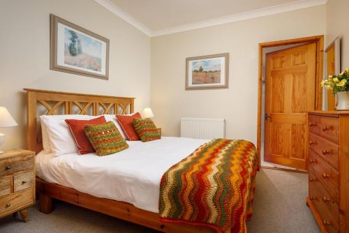 a bedroom with a bed and a wooden dresser at The Roundhouse in Redruth