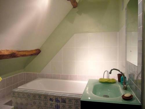 a bathroom with a bath tub and a sink at MANOIR DU TERTRE au coeur de la forêt de Brocéliande in Paimpont