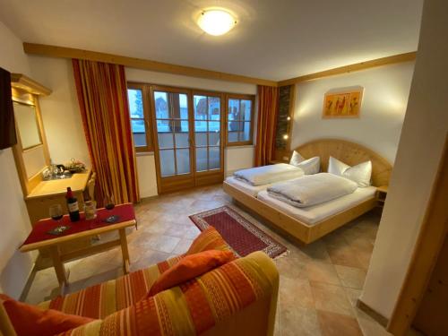 Sala de estar con 2 camas y mesa en Gafluna en Sankt Anton am Arlberg