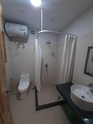 ein Bad mit einer Dusche, einem WC und einem Waschbecken in der Unterkunft Ma-Chhim Furnished Apartment in Thimphu