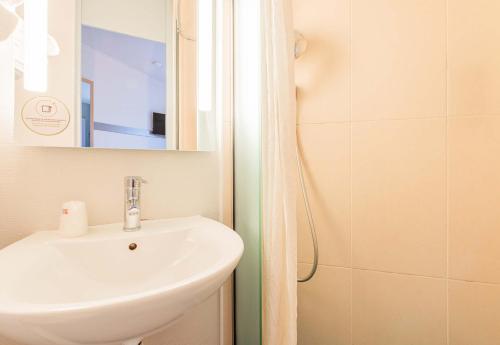 a bathroom with a sink and a shower at B&B HOTEL Colmar Vignobles Ouest in Colmar