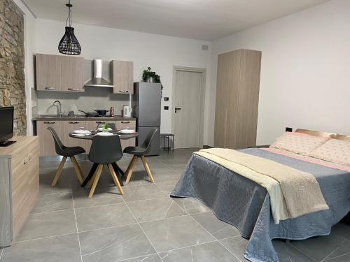 a bedroom with a bed and a table and a kitchen at Casa vacanze Savà in Lagaro