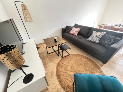 un salon avec un canapé et une table dans l'établissement Villa La Pause 6 voyageurs, à Saint-Rémy-de-Provence