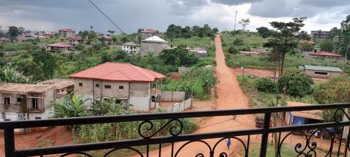 uma vista para uma aldeia com uma estrada de terra em Olympus House em Iaundé