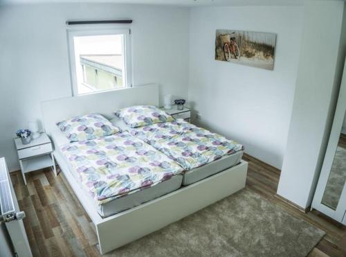 um quarto branco com uma cama e uma janela em Schönes Haus mit großem Garten em Seligenstadt