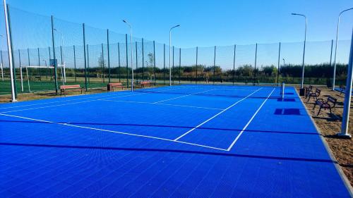 a tennis court with a net and benches on it at PIONOW Pokoje WaWa - adults only in Krynica Morska