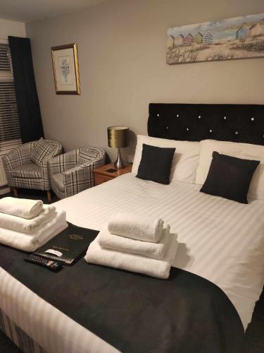 a bedroom with a large white bed with towels on it at Q Accommodation in Blackpool