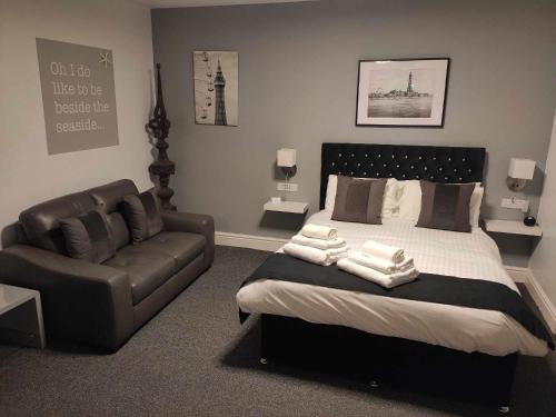 a bedroom with a bed and a leather couch at Q Accommodation in Blackpool