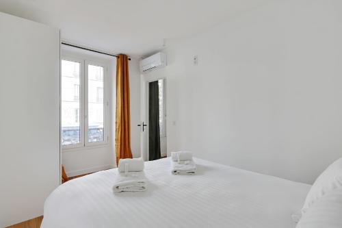 une chambre blanche avec un grand lit blanc et une fenêtre dans l'établissement Pick A Flat's Apartement in Nation - rue d'Avron, à Paris