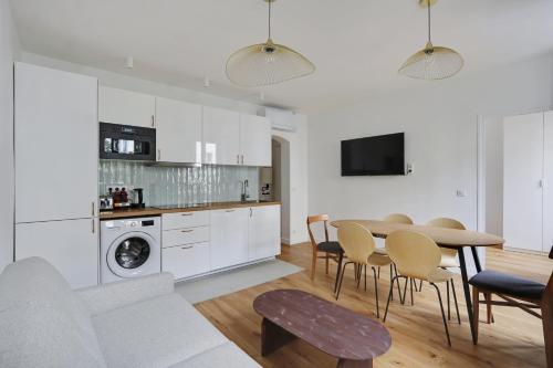 une cuisine et un salon avec une table et des chaises dans l'établissement Pick A Flat's Apartement in Nation - rue d'Avron, à Paris
