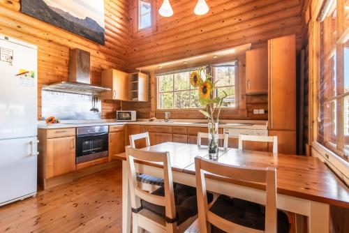 La cuisine est équipée d'une table, de chaises et d'un réfrigérateur. dans l'établissement Home2Book Cozy Cottage Arucas, Porch, Garden & BBQ, à Arucas