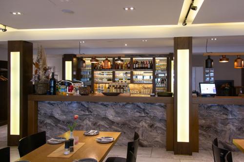 un restaurante con 2 mesas y un bar en ASD Hotel en Filderstadt