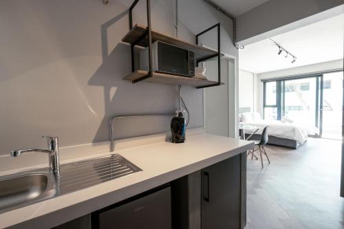 a kitchen with a sink and a microwave at Inn & Out Plus Rosebank in Johannesburg