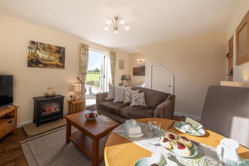 ein Wohnzimmer mit Sofa und Tisch in der Unterkunft Couples Retreat in Beautiful West Devon Countryside in Broadwoodwidger